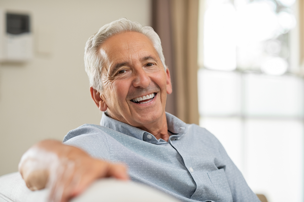 Smiling senior man relaxing on a sofa at home