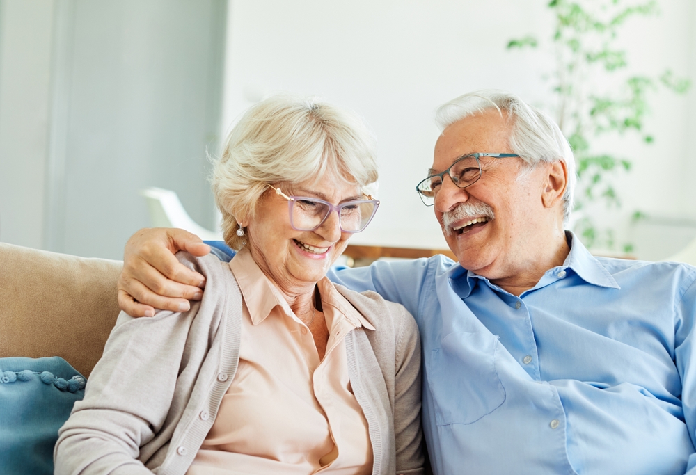 Smiling senior couple sitting together on a sofa