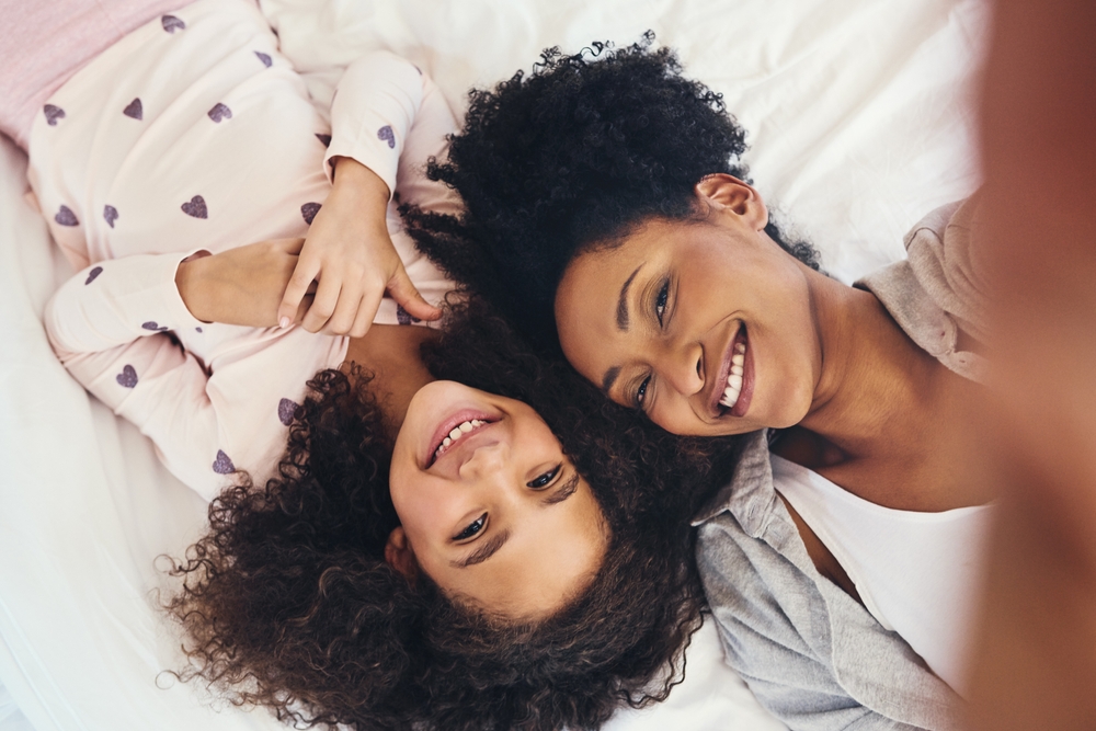 Smiling mother and daughter lying side by side